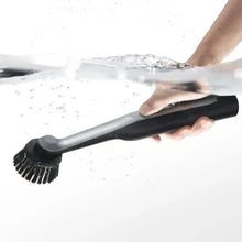 Cordless spin scrubber cleaning with round bristle brush head on a wet surface