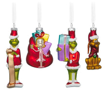 Glass ornament of red-clad elf holding a small gift, green face, white trim Santa hat