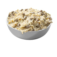 Creamy pasta stroganoff in a white bowl, with chunks of meat and sauce