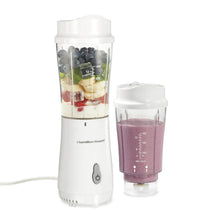 White personal blender base with blending jar and travel jar filled with purple smoothie