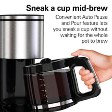 Coffee maker with auto pause handle and glass carafe, hand holding the handle