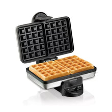 Belgian waffle maker with open lid and two square waffles on black nonstick grids