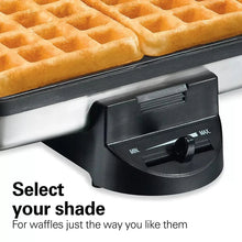Belgian waffle maker with golden square waffles in the tray and front temperature dial