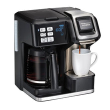Black coffee maker with digital panel, carafe and filled mug