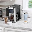 Hamilton Beach FlexBrew 6-in-1 coffee maker in kitchen setup near cups and coffee tools