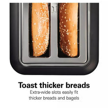 2-slice toaster with two extra-wide slots holding toasted bread halves with seeds