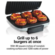 Indoor electric grill with open lid, grilling surface topped with sliced burgers