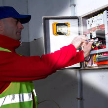 Orange work light attached to an electrical panel inside a garage