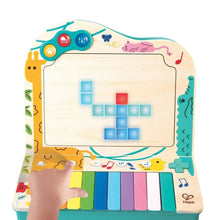 Pixel piano arcade front panel with blue grid, red/blue squares, and rainbow keys