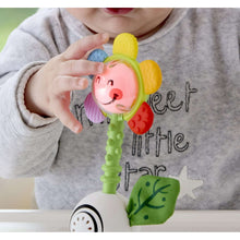 Infant flower light-up rattle with smiling face, green handle and colorful petal ends