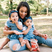 Yogis snack pouch held by child in denim overalls