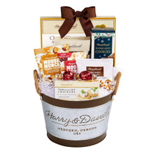 Gift basket with ribbon bow, filled with cookies, crackers, and caramel chocolate