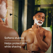 Man spreading white shaving foam on his face with Harry's shave cream