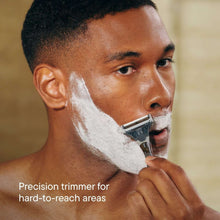 Men's razor being used to shave stubble, with textured grip in hand
