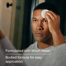 Blue facial toner bottle with cap, beside a man applying toner to his face