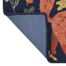 Hooked accent rug edge in dark navy with textured hooked fibers and colorful motif