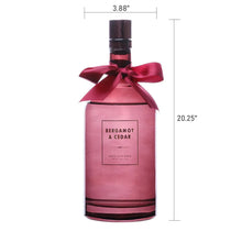 Reed diffuser bottle with size markings, pink glass, “Bergamot & Cedar” label, ribbon bow