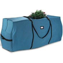 Christmas tree storage bag in blue with black carry handles and straps, holding a small tree