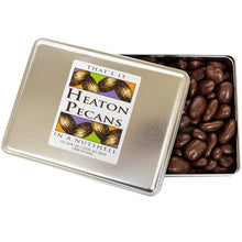 Chocolate-covered pecans in open metal tin, lid with product label