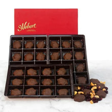 Assorted milk chocolate caramels with cranberry and cashew in open box