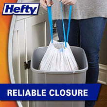 Kitchen trash bag with blue drawstring closure above a trash can