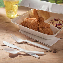 White plastic cutlery with wrapped utensils on table near food tray
