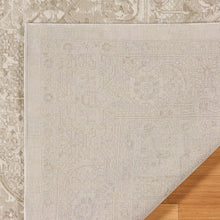 Beige area rug section with geometric medallion pattern and low, flat woven look.