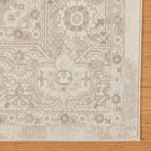 Beige area rug corner with ornamental motifs and distressed tone-on-tone design.