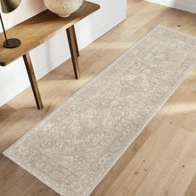 Beige area rug with distressed medallion and floral pattern, flat-woven style
