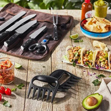 BBQ utensil set laid out on a work surface: knives, fork, and grill tool
