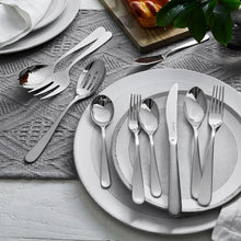 Stainless steel flatware on plate: forks, spoon, and knife with polished handles