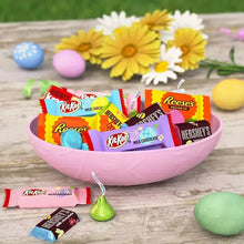 Assorted wrapped chocolates in an Easter bowl with decorative eggs and candy pieces
