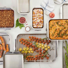 Quarter sheet pan with wire rack holding roasted vegetables and herbs in a kitchen setup