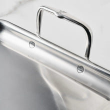 Stainless steel griddle with curved carry handle and smooth cooking basin