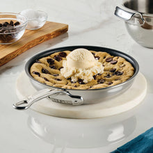 Nonstick skillet filled with dessert cookies, stainless handles, and black interior coating.
