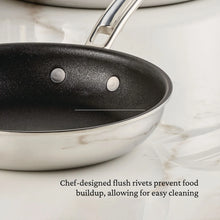 Nonstick skillet side close-up with black interior, stainless rim, and two flush rivets.