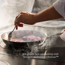 Stainless steel skillet with steaming cooking surface and side handles