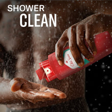 Red body wash bottle dispensing on hands with water spray