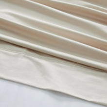 Light beige sheet set fabric with stitched hem and subtle woven texture