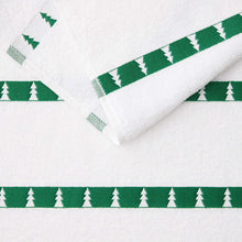 White kitchen towel with green tree border strip and small tree icons.