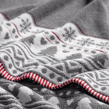 Bath towel close-up in dark gray with red and white snowflake and patterned trim