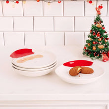 Stacked white Santa face plates with red rims and a holiday cookie