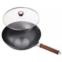 Carbon steel wok with glass lid and dark wood handle with metal attachment