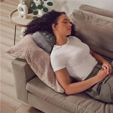 Gray contoured gel massage pillow used on a sofa with padded neck support