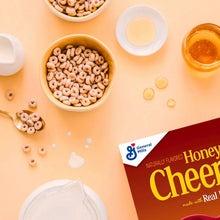 Honey nut flavored cereal rings in bowls with honey and milk