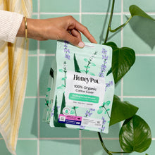 Honey Pot cooling herbal infusion organic cotton cover pads, 16 count pack held in hand
