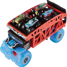 Red monster truck hauler with open top carrying several multicolor monster trucks and blue wheels