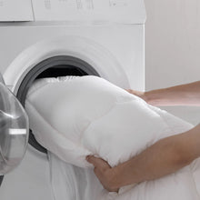 Polyester-filled mattress topper being lifted from a white cover
