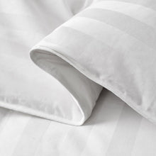 White comforter fabric close-up with neatly stitched edge