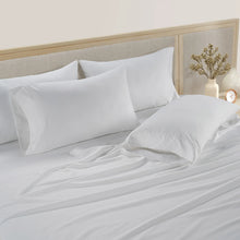 White cotton sheet set with pillowcases on bed, visible drape and folds